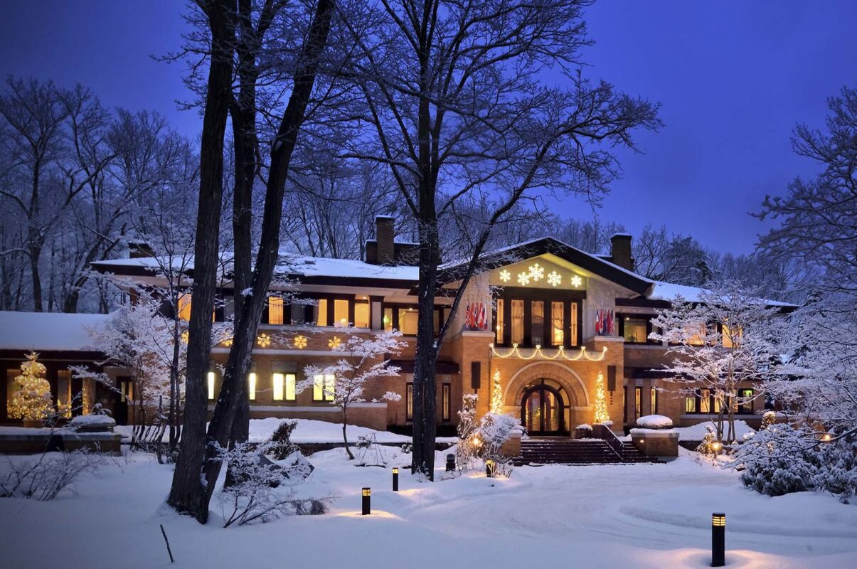 twilight shot of the la Neige Hotel in Hakuba with hotels lights on and snow in foreground.