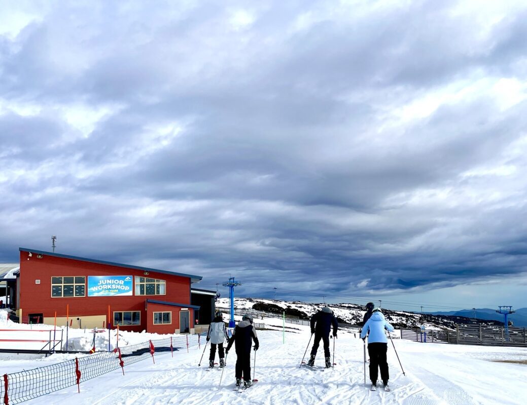 Image of skiers at Falls Creek as clouds roll in