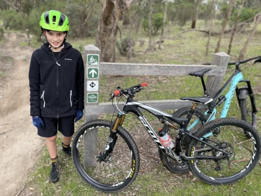 Trail signage and rider at Lysterfield mountain bike park