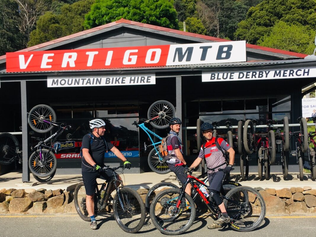 Mountain bike riders in front of bike and hire shop at Derby, Tasmania.