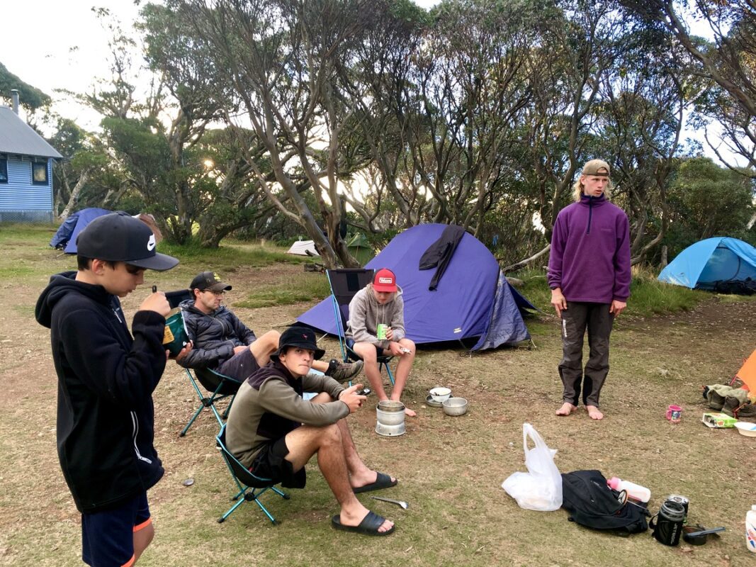 Campers and tents at the Federation Hut campground with hut in the background,