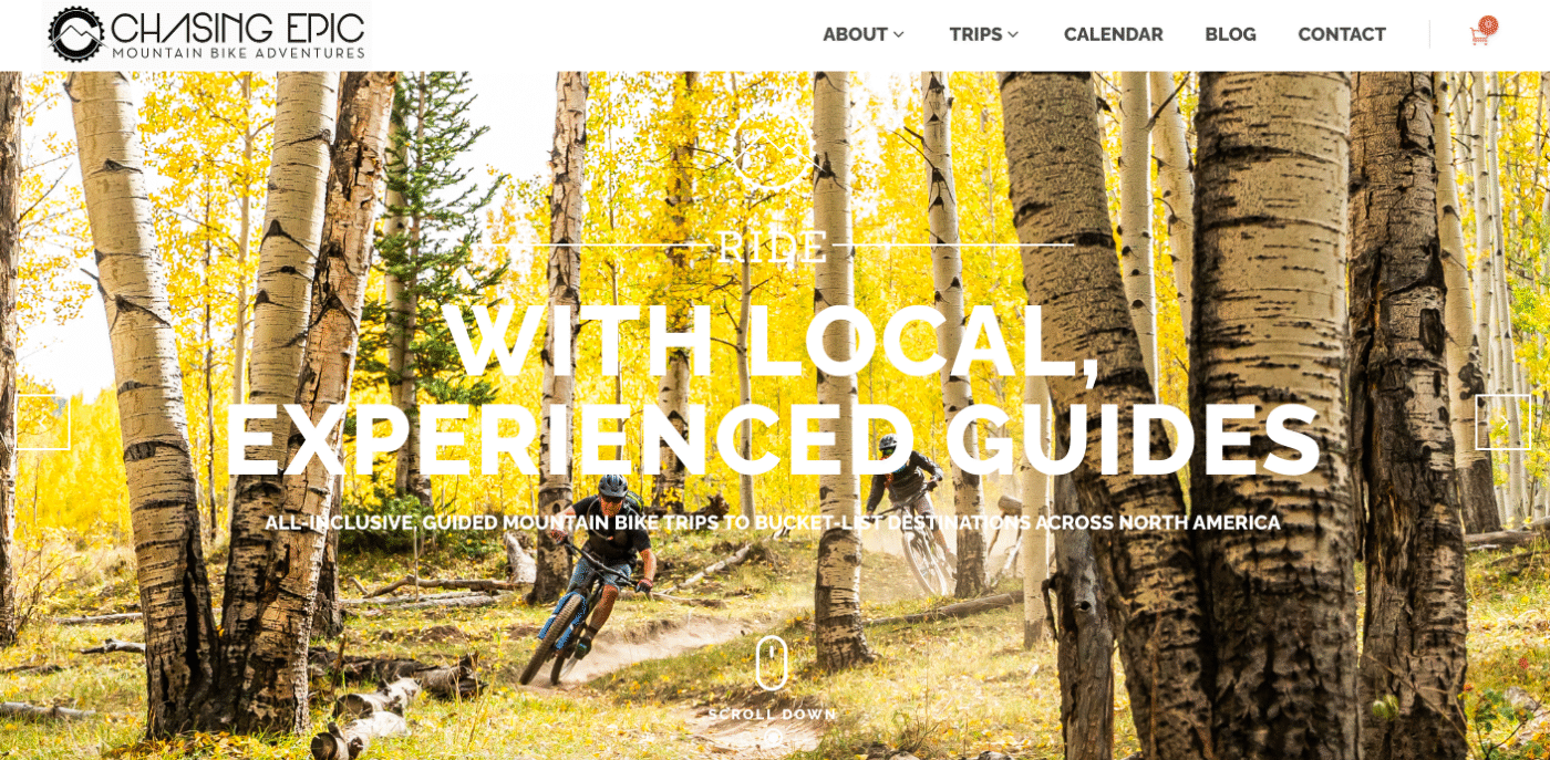 Screenshot of home page of Sacred Rides mountain bike tour operator with mtb rider Son singletrack through autumn tress with a yellow glow.