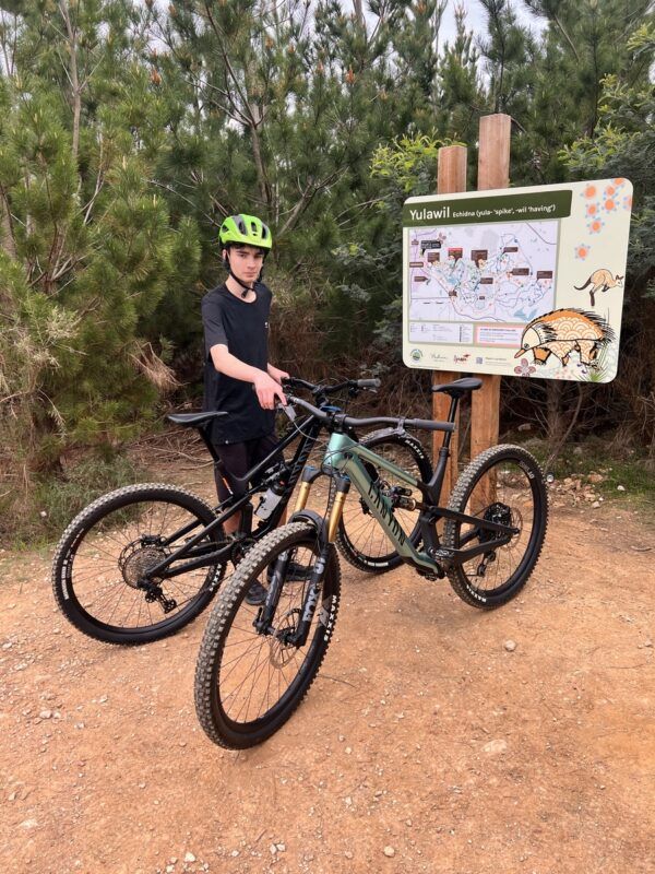 Rider holding an mtb in front of the Gravity trails junction map at Creswick mtb park