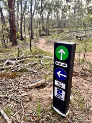 Beechworth Mountain Bike Park signage with mtb singletrack in the background