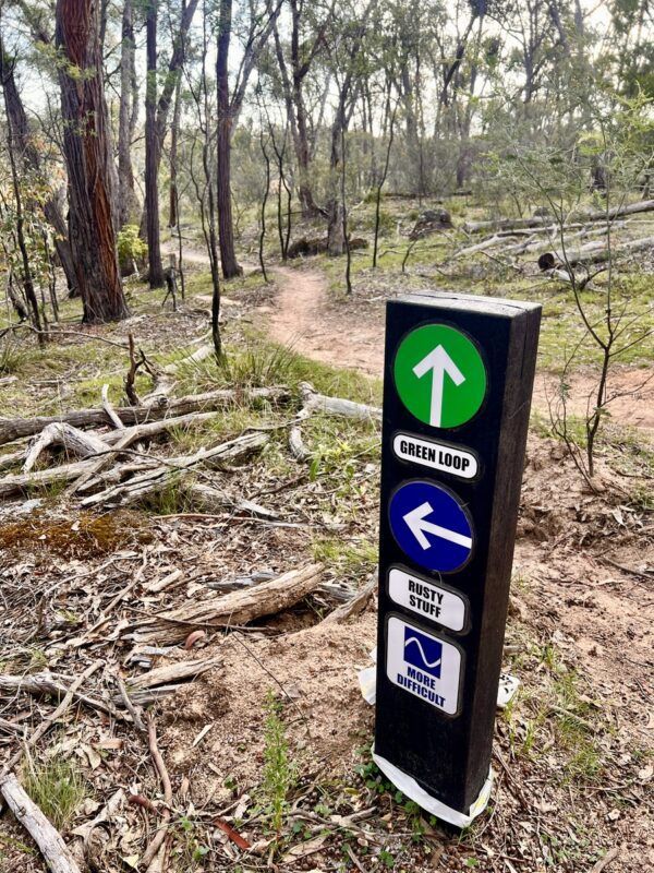 Beechworth Mountain Bike Park signage with mtb singletrack in the background